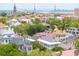 An aerial view of historic Charleston rooftops, lush greenery, and the Ravenel Bridge in the distance at 61 Tradd St, Charleston, SC 29401