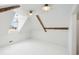 Spacious attic with painted floors, exposed beams, natural light from the window, and modern light fixtures at 61 Tradd St, Charleston, SC 29401