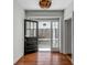Inviting entryway featuring hardwood floors, black door with glass panes, and a view to a spacious porch at 61 Tradd St, Charleston, SC 29401