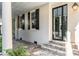 Charming home exterior featuring a brick porch, pillars, black shutters, and a black-framed glass door at 61 Tradd St, Charleston, SC 29401