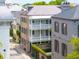 Charleston home featuring double porches and a wrought iron gate, nestled among neighboring buildings and green landscaping at 61 Tradd St, Charleston, SC 29401