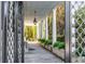 A brick walkway with manicured greenery leads to a white columned portico and the main entrance at 61 Tradd St, Charleston, SC 29401