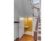 Hallway leading to a small powder room, featuring hardwood floors and a staircase at 61 Tradd St, Charleston, SC 29401