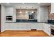 Elegant kitchen features exposed brick, white cabinetry, black countertops, and hardwood flooring at 61 Tradd St, Charleston, SC 29401