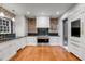 Spacious kitchen featuring exposed brick, stainless steel appliances, and beautiful hardwood floors at 61 Tradd St, Charleston, SC 29401