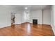 Bright living room with hardwood floors, fireplace, ceiling fan, and doorway to the stairs at 61 Tradd St, Charleston, SC 29401