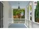Covered porch with blue ceiling, classic columns, white railings, and a view of the landscaped garden at 61 Tradd St, Charleston, SC 29401