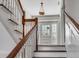 Classic staircase with wood railing and white spindles leading to an inviting entryway with glass doors at 61 Tradd St, Charleston, SC 29401