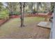 Overhead shot of the backyard with green grass, a fire pit, a wooden fence, and a wood deck at 703 Canary Dr, Charleston, SC 29414
