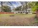 The house backs to an expansive backyard with mature trees, a fire pit and a wooden fence at 703 Canary Dr, Charleston, SC 29414