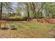Shot of a large backyard with wooden fence, fire pit and lush green grass and leaves at 703 Canary Dr, Charleston, SC 29414
