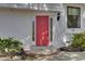 Close-up of a vibrant red front door with sidelights, set against a white brick facade, showing detail and charm at 703 Canary Dr, Charleston, SC 29414