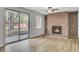 Cozy living room offers a brick fireplace, contemporary flooring, and sliding glass door access to the backyard at 703 Canary Dr, Charleston, SC 29414