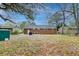 Leafy backyard area with a brick home, patio, and mature trees at 746 Cartwright Dr, Charleston, SC 29414