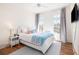 Bright bedroom featuring hardwood floors, two windows with gray curtains, and a comfy bed with lots of pillows at 772 Post Oak Dr, Mount Pleasant, SC 29464