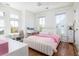 This bedroom has hardwood floors, bright windows, a small desk, and a comfy bed with a pink coverlet at 772 Post Oak Dr, Mount Pleasant, SC 29464
