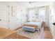 Cozy bedroom with hardwood floors, light blue walls, and ample sunlight from windows with sheer curtains at 772 Post Oak Dr, Mount Pleasant, SC 29464
