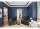 Elegant living room showcasing navy walls, two green chairs, and seamless doorway access at 772 Post Oak Dr, Mount Pleasant, SC 29464