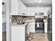 Kitchen with white cabinets, stainless appliances, modern tile backsplash, and laminate counters and flooring at 7940 Parklane Ct # F, North Charleston, SC 29418