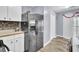 Spacious kitchen with stainless refrigerator, white cabinets, and hardwood floors at 7940 Parklane Ct # F, North Charleston, SC 29418