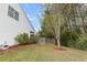 Landscaped backyard with mulch beds, green grass, white siding, and a wooden fence at 9411 Harroway Rd, Summerville, SC 29485