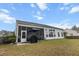 Back exterior view of the screened in porch, gazebo, and green lawn under a blue sky at 9411 Harroway Rd, Summerville, SC 29485