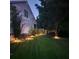 Backyard with illuminated landscaping that enhances the home's exterior at 9411 Harroway Rd, Summerville, SC 29485