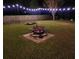 Backyard fire pit area with lights and patio for cozy outdoor gatherings at 9411 Harroway Rd, Summerville, SC 29485