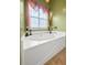 Corner bathtub beside a window, in a bathroom with green walls at 9411 Harroway Rd, Summerville, SC 29485