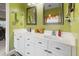 Bathroom with double vanity sinks and decorative mirrors and light green walls at 9411 Harroway Rd, Summerville, SC 29485