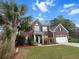 Traditional brick home with lush front lawn, and an American flag at 9411 Harroway Rd, Summerville, SC 29485