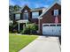 Classic brick home featuring a manicured lawn, attached garage and inviting front porch at 9411 Harroway Rd, Summerville, SC 29485