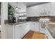 Bright kitchen featuring white cabinets, granite countertops, stainless steel appliances, and hardwood floors at 9411 Harroway Rd, Summerville, SC 29485