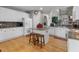 Bright kitchen design featuring white cabinets, an island with stools, stainless steel appliances, and hardwood floors at 9411 Harroway Rd, Summerville, SC 29485
