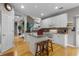 Open kitchen design featuring white cabinets, granite countertops, an island with stools, and hardwood floors at 9411 Harroway Rd, Summerville, SC 29485