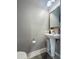 A cozy powder room with a pedestal sink, decorative mirror, and tiled floor offering a touch of style and convenience at 9411 Harroway Rd, Summerville, SC 29485