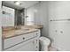 Bright bathroom with marble countertop, white cabinets, toilet, and view of shower in the mirror at 1 King St # 209/210, Charleston, SC 29401