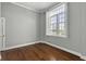 Bright bedroom featuring hardwood floors, a large window with shutters, and neutral wall paint at 1 King St # 209/210, Charleston, SC 29401