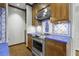 Kitchen featuring wood cabinets, blue countertops, backsplash with design, and stainless steel appliances at 1 King St # 209/210, Charleston, SC 29401