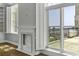 Bright living room boasts a fireplace, plantation shutters, and scenic waterfront views at 1 King St # 209/210, Charleston, SC 29401