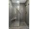 Tiled shower featuring a glass door, rainfall shower head, handheld sprayer, and built-in seat at 1 King St # 209/210, Charleston, SC 29401