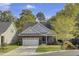 Charming brick home with a well-manicured lawn, two-car garage, and lush trees at 102 Brutus Ln, Summerville, SC 29485