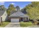 Charming brick home with a well-manicured lawn, two-car garage, and lush trees at 102 Brutus Ln, Summerville, SC 29485