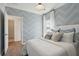 Charming bedroom featuring patterned wallpaper, ample natural light, and a door to the ensuite bath at 1020 Sagegrass St, Summerville, SC 29485