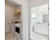 Bright laundry room with white washer and dryer next to the bathroom with white cabinets and marble tile flooring at 1020 Sagegrass St, Summerville, SC 29485