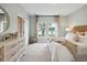 Bright bedroom featuring large windows, a woven headboard, and a view of a serene lake at 1025 Swamp Rose Run, Summerville, SC 29485