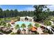 Relaxing poolside amenities featuring multiple palm trees, lounge chairs and covered outdoor eating area at 1025 Swamp Rose Run, Summerville, SC 29485