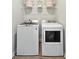 Efficient laundry room featuring a white washer and dryer with wire shelf storage above at 1025 Swamp Rose Run, Summerville, SC 29485