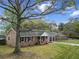 Traditional brick home with a gabled porch, rocking chairs, black shutters and an attached garage at 103 Beverly Dr, Ladson, SC 29456