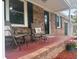 Covered front porch with chairs, potted flowers, and front door with transom window at 103 Beverly Dr, Ladson, SC 29456